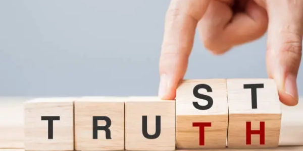 Business man hand change wooden cube block with TRUST and TRUTH business word on table background. Trustworthy, faith, beliefs and honesty concept