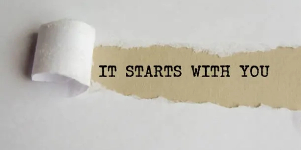 IT STARTS WITH YOU. words. text on grey paper on torn paper background.