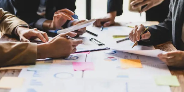 Brainstorm business meeting to discuss analysis of financial figures, graphs and growth charts of business investments to plan new business projects.